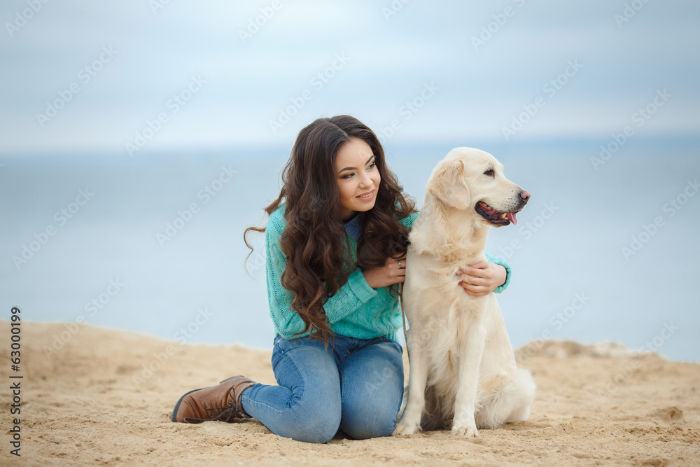 portrait of Beautiful woman with her dog on the beach near sea