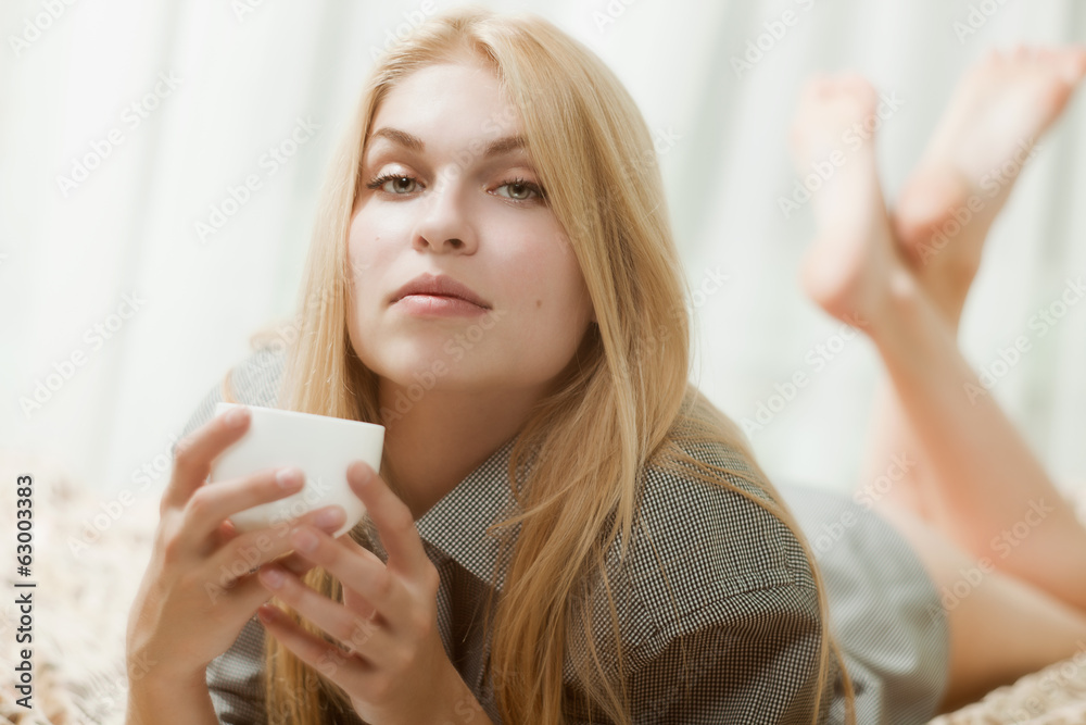 Beautiful woman with cup on bed Beautiful woman with cup on bed