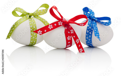 Three Easter eggs with festive bow isolated on white background
