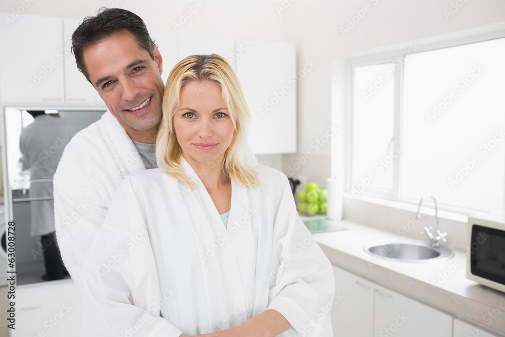 Man embracing woman from behind in kitchen Man embracing woman from behind in kitchen