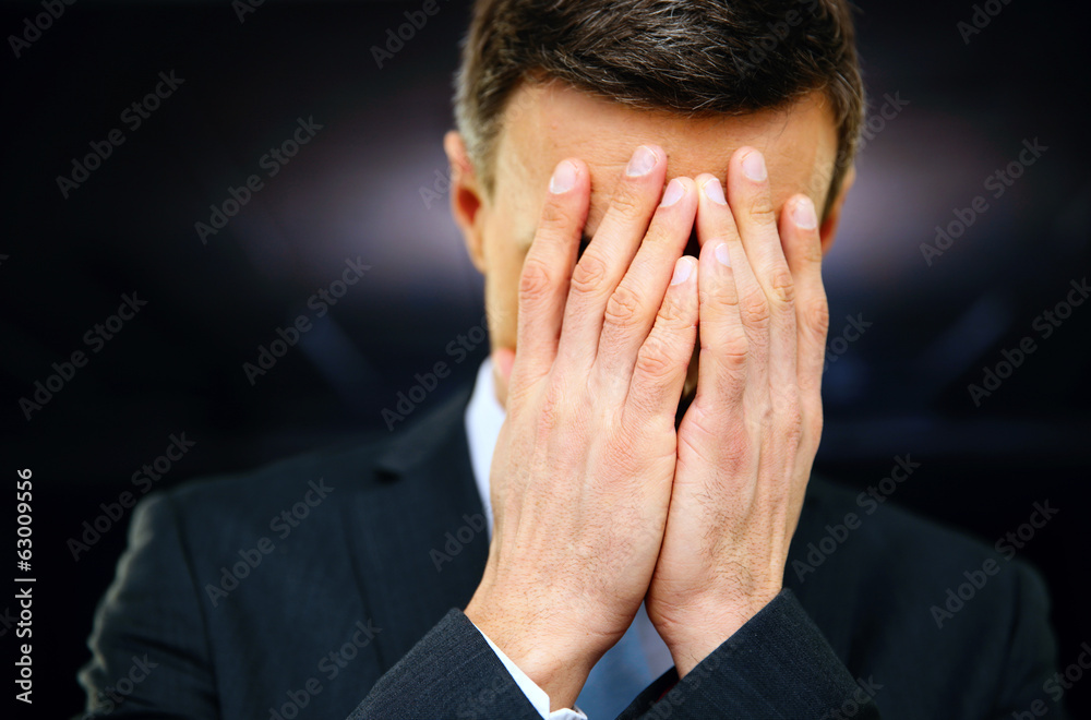 Frustrated businessman with hands on face Frustrated businessman with hands on face