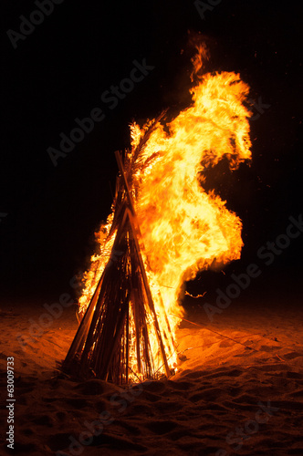 Canvas Print A pyre burning in the night on a beach during summer holidays.
