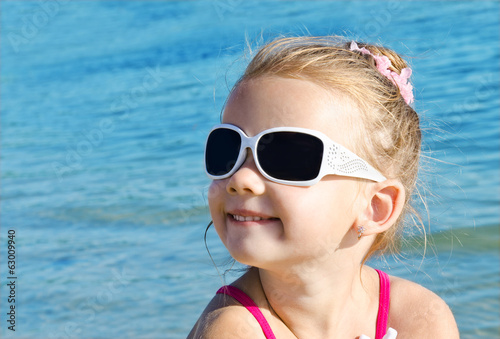 Adorable smiling little girl on beach vacation