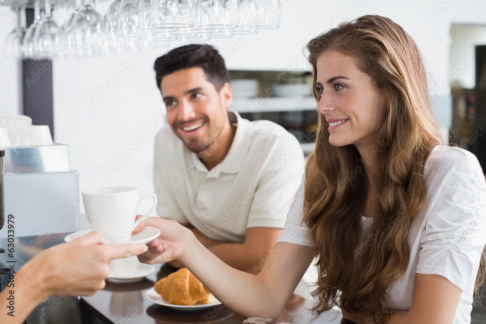 Hand giving coffee to a couple at coffee shop Hand giving coffee to a couple at coffee shop