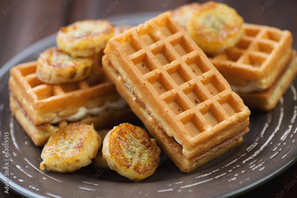 Waffles served with fried banana, close-up, studio shot