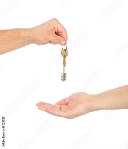 Male hand holding a car key and handing it over to another perso