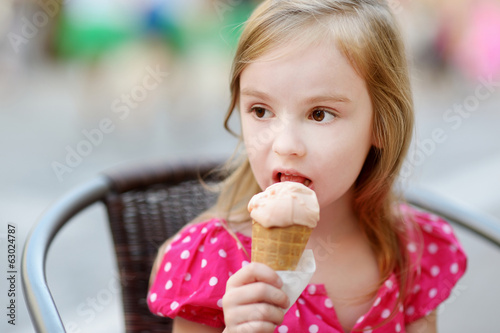 Adorable little girl eating ice-cream outdoors