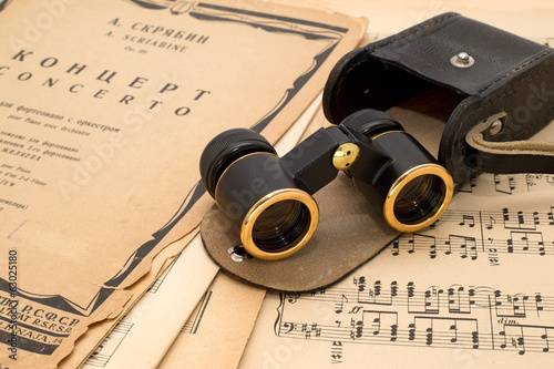 Opera glasses with case on an ancient music score background