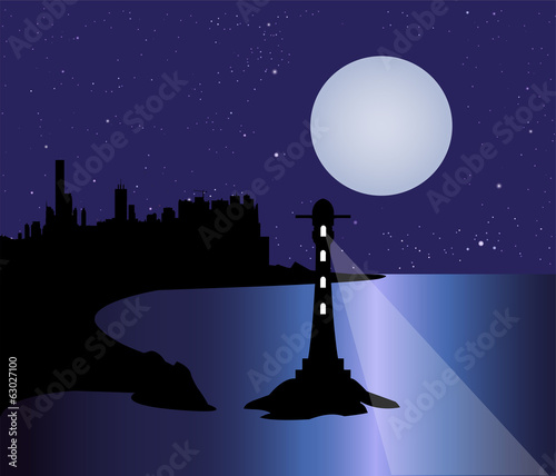 città sulla costa e faro nella notte