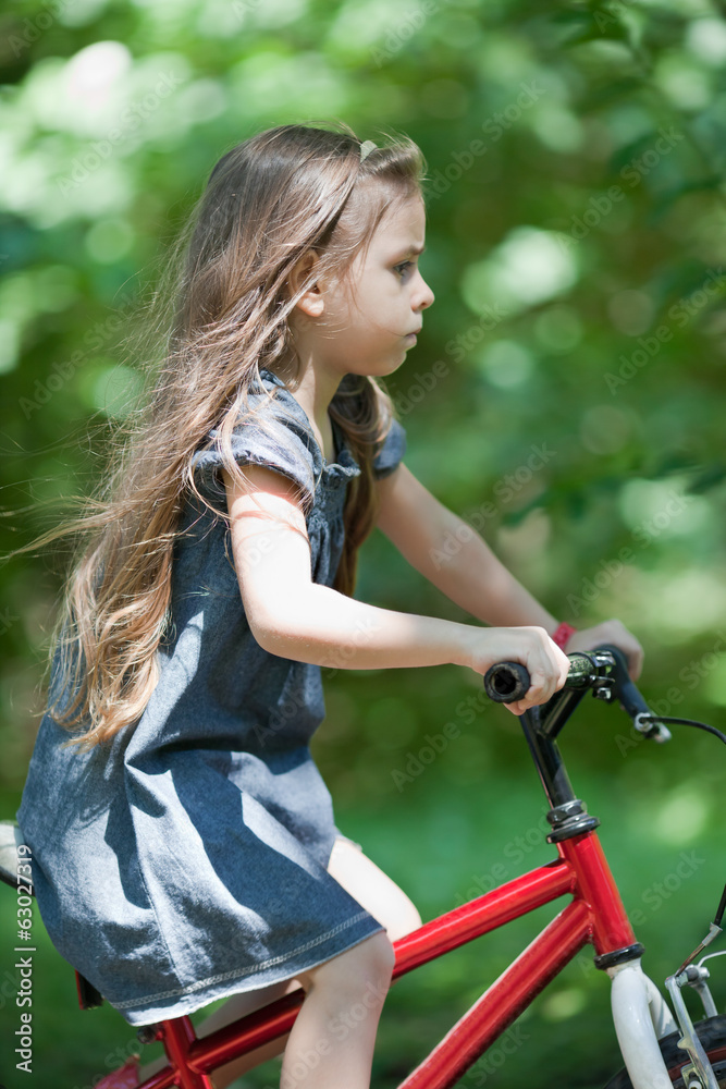 Fototapeta premium Little girl riding bicycle