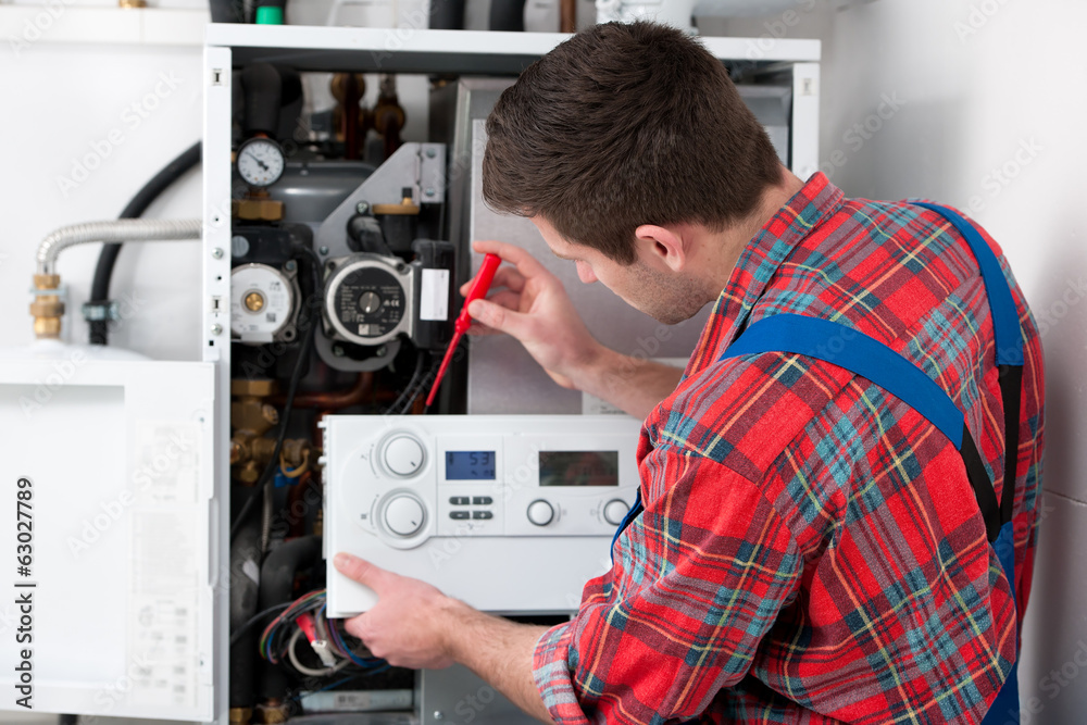 Obraz premium Technician servicing heating boiler