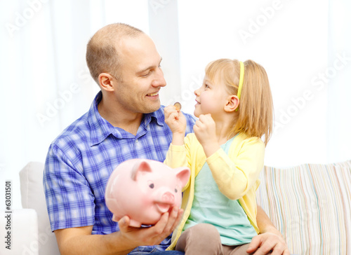 happy father and daughter with big piggy bank