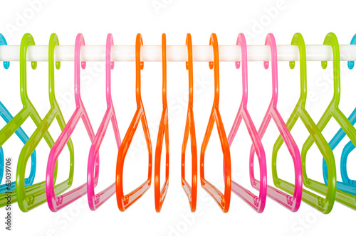 Colored hangers on a rod in a wardrobe