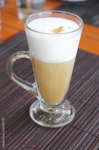 coffee latte with frothy milk in tall glass.