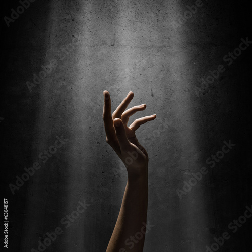 Obraz na płótnie woman's hand reaches for the light rays w salonie