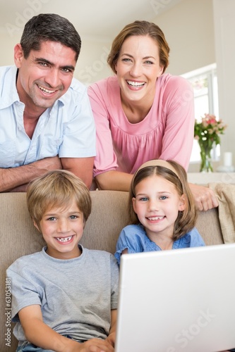 family with laptop in living room