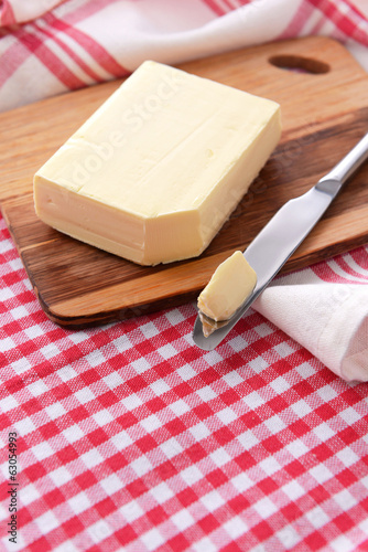 Tasty butter on wooden cutting board