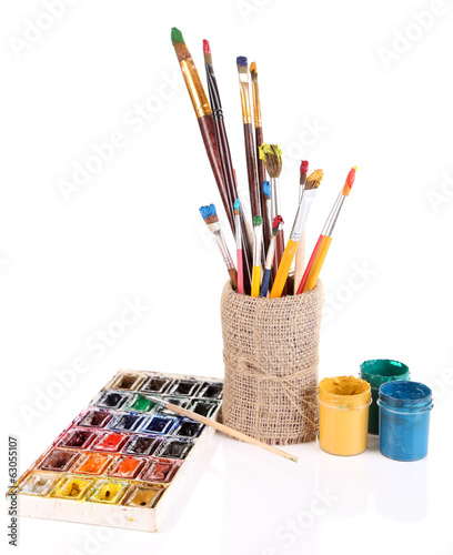 Composition with brushes in vase and paints isolated on white