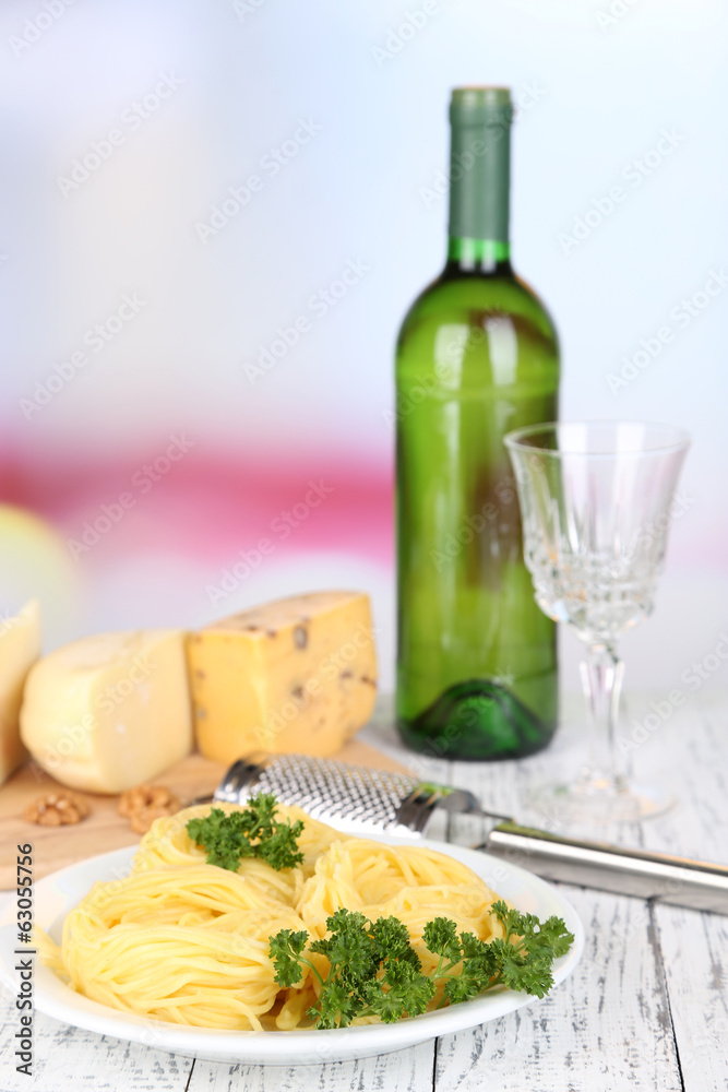 Composition with tasty spaghetti, grater, cheese, wine bottle