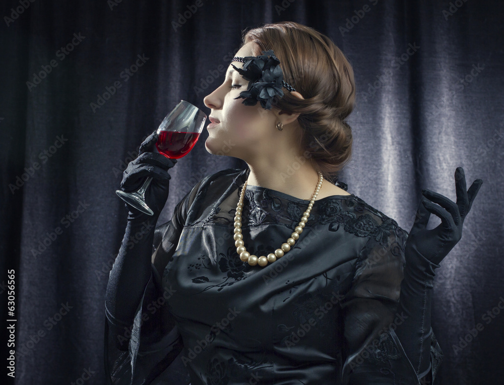 Beautiful woman in a retro style with a glass of red wine. Beautiful woman in a retro style with a glass of red wine.