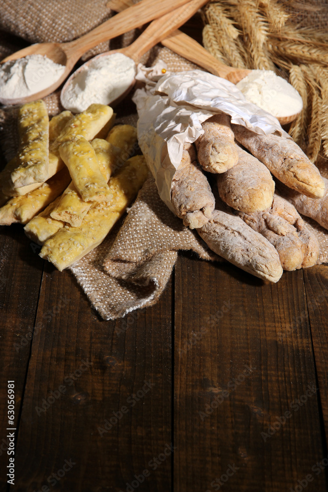 Fototapeta premium Bread sticks on sackcloth on wooden background