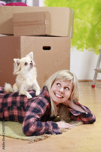 Woman with dog lying on the floor in front of cardboxes photo