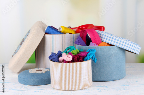 Tableau sur toile Decorative boxes with colorful skeins of thread and zippers