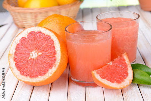 Photo Ripe grapefruit with juice on table close-up