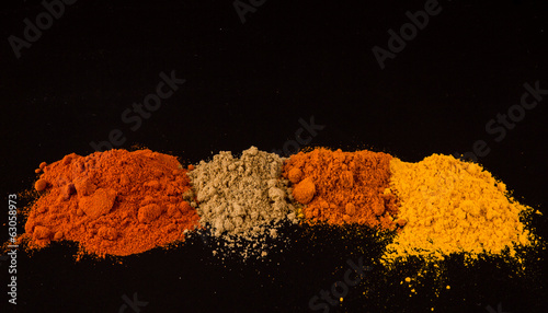 Mix powdered spices on black background