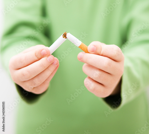 Young girl is breaking a cigarette