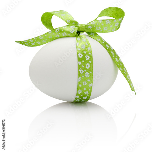 Easter egg with festive green bow isolated on white background