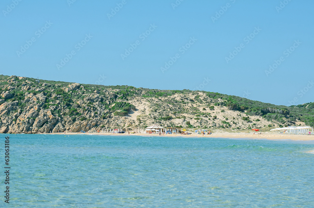Obraz premium Tropical beach with deckchairs, umbrellas and people.