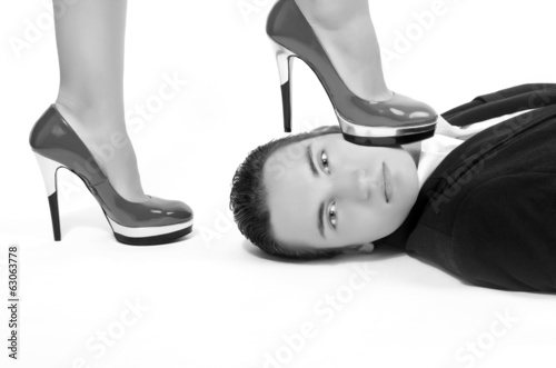 Woman in control of a man, sexy woman' foot on a man' face photo