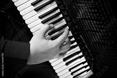 фотографія musician plays the accordion against a dark background