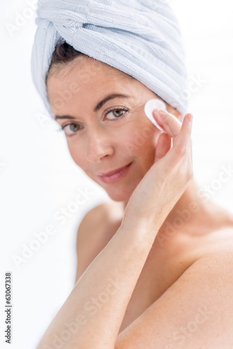 Mature lady using a cotton pad to clean her skin