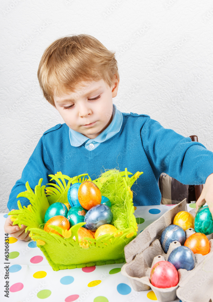 Little toddler boy being happy about selfmade Easter egg