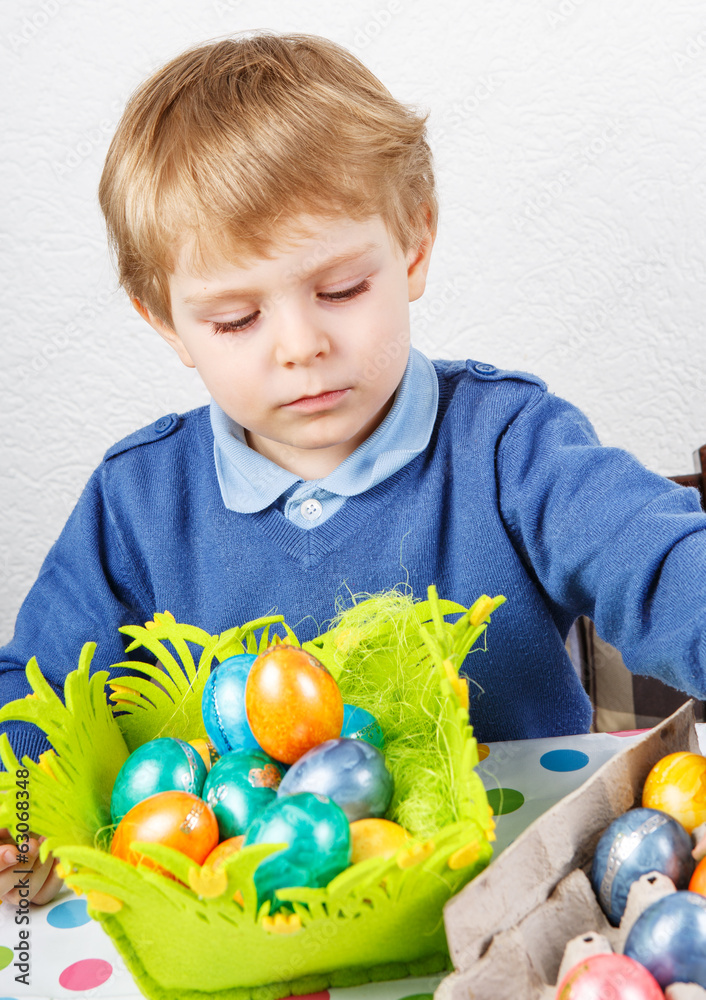 Fototapeta premium Little toddler boy being happy about selfmade Easter egg