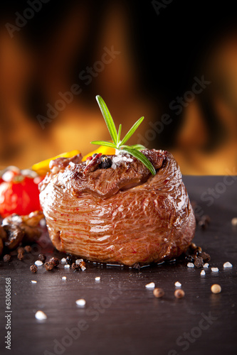 Fresh beef steak on black stone and fire