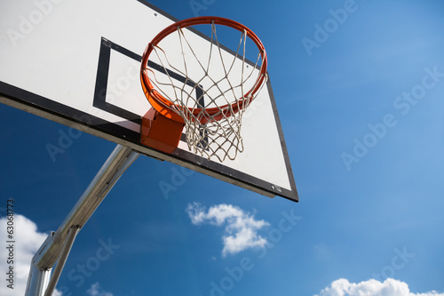 Basketball hoop against lovely blue summer sky