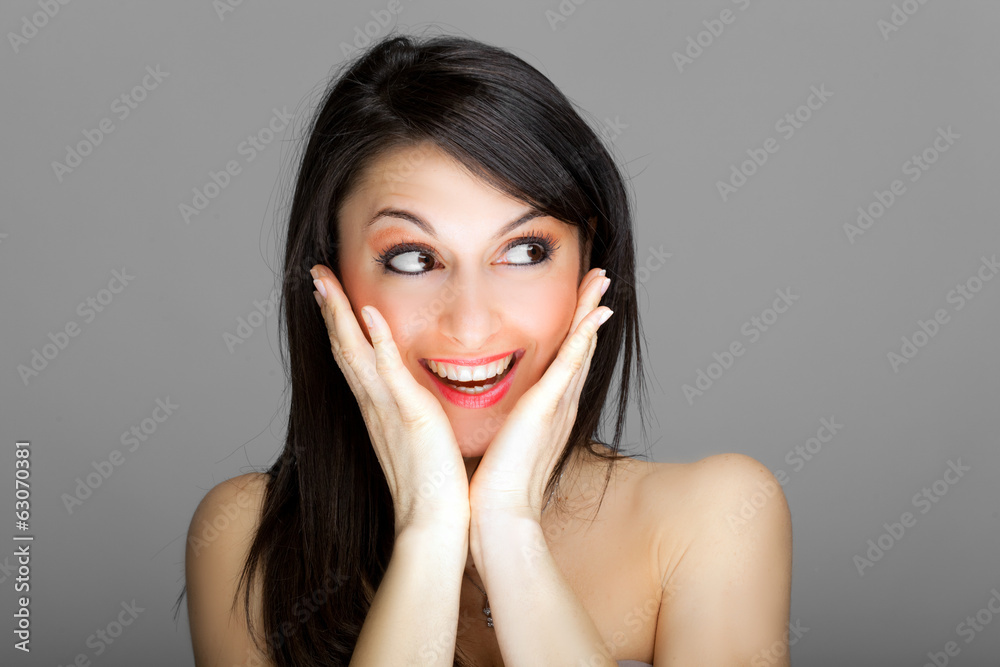 Beautiful surprised woman against a grey background Beautiful surprised woman against a grey background