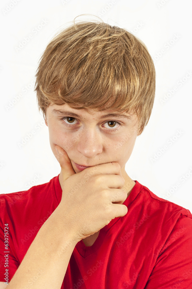handsome boy in red shirt keeps hand at chin handsome boy in red shirt keeps hand at chin