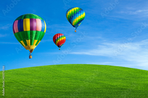 Hot air balloons over green field © Mariusz Blach