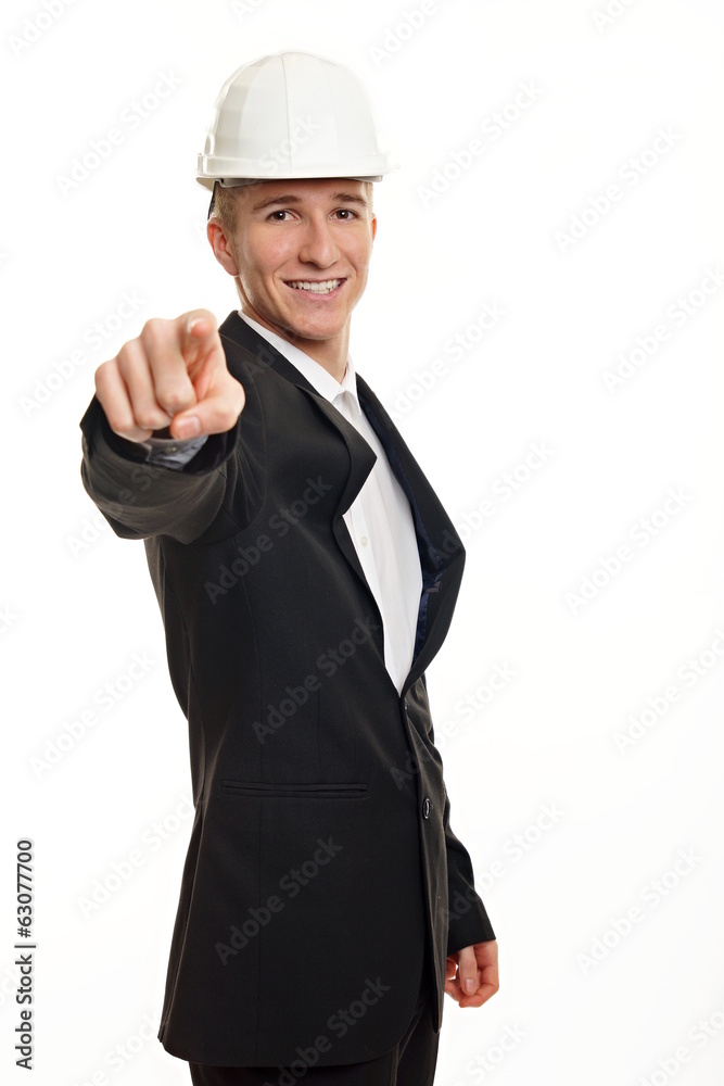 Young man in suit with a white protective helmet shows on you