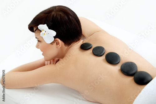 Spa Tretment. Beautiful Woman Getting Stones Massage in Salon