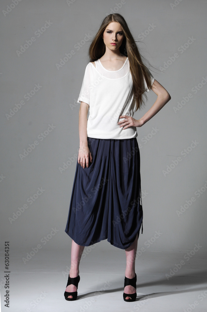 Young beautiful smiling stylish woman isolated on gray