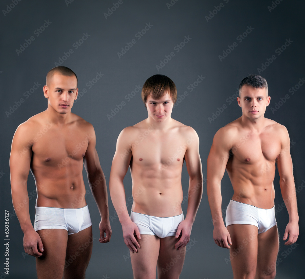 Foto Stock Sexy muscular guys advertises briefs in studio | Adobe Stock