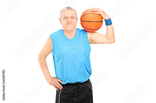 Mature man holding a basketball over his shoulder