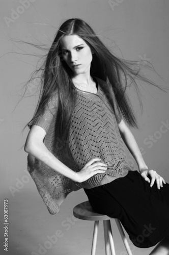 Young beautiful smiling stylish woman sitting chair