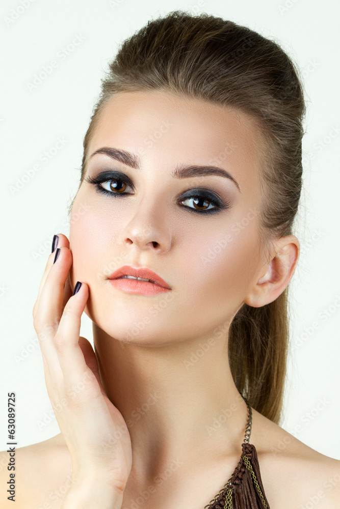 Beauty portrait of young woman touching her face Beauty portrait of young woman touching her face