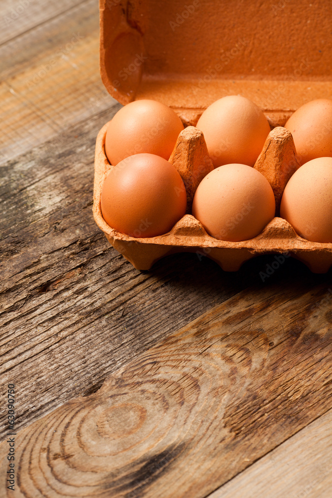Eggs in the package on wooden table Eggs in the package on wooden table